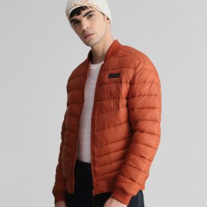 Men's puffer jacket in burnt orange with a white knitted beanie, offering warmth and style for the colder months.